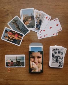 several playing cards are laid out on a table with an open cell phone in front of them