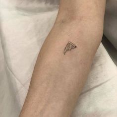 a small slice of pizza tattoo on the arm