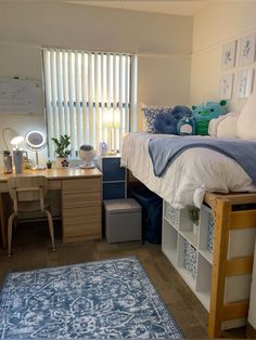 a bedroom with a bed, desk and chair in it next to a blue rug