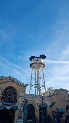 the entrance to mickey mouse's amusement park in disney world, with a water tower behind it