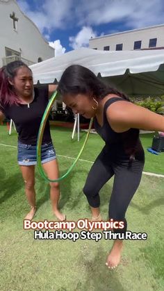 two women are playing with hula hoop in the grass