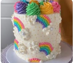 a person is decorating a cake with rainbow icing