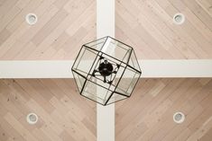 an overhead view of a light fixture in a room with wood floors and white walls