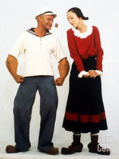 a man and woman standing next to each other in front of a white wall wearing pirate costumes