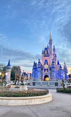 the castle is lit up at night with blue and pink lights on it's sides