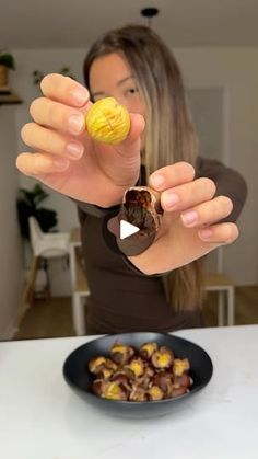 a woman is holding up some food in her hands