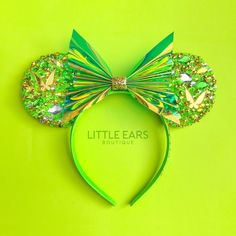 a green minnie mouse ears headband with sequins and bows on it's side