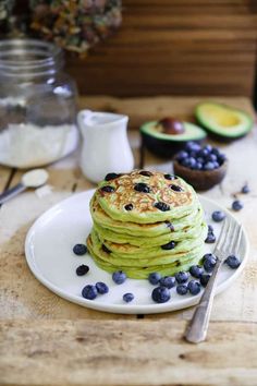 a stack of pancakes with blueberries and avocado