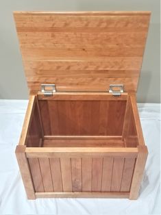 an empty wooden box sitting on top of a white sheet