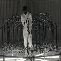 a man standing in front of microphones on top of a table