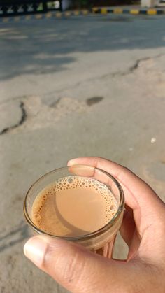 a person holding a cup of coffee in their hand