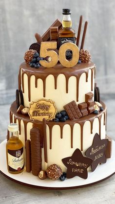 a 50th birthday cake with liquor and chocolate decorations on the top, sitting on a white plate