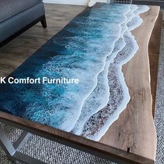 a coffee table with an ocean scene painted on the top, and two couches in the background