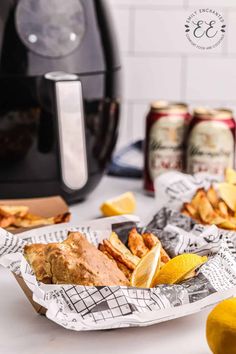 a basket full of food sitting on top of a table next to two cans of soda