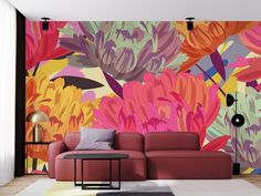 a living room with colorful floral wallpaper on the walls and a red couch in front of it