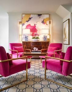 a living room filled with pink chairs and a rug on the floor in front of a painting