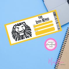 a lion king ticket sitting on top of a desk next to a laptop