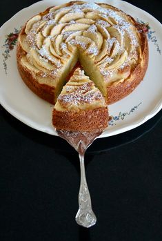 a cake on a plate with a slice cut out and being held by a fork