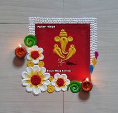 a decorated frame with flowers and candles on a wooden surface for diwaling or decorating