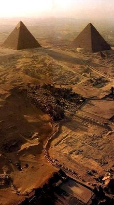 an aerial view of three pyramids in the desert