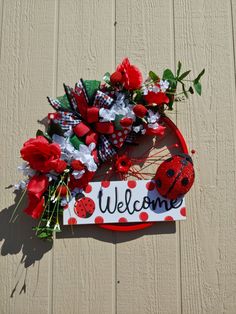 the welcome sign is decorated with flowers and ladybugs