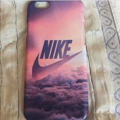 a phone case with the nike logo on it sitting on top of a bed covered in clouds