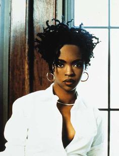 a woman with large hoop earrings sitting in front of a window