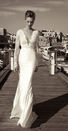 a woman in a wedding dress standing on a dock