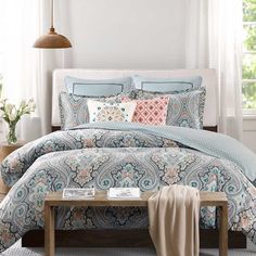 an image of a bed with blue and pink comforter set on it's side