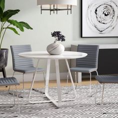 a white table and chairs in a room with a rug on the floor next to it