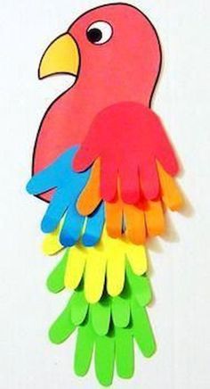 a colorful bird made out of paper on top of a white surface with scissors in it's beak