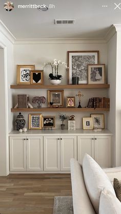 a living room filled with lots of furniture and pictures on the wall above it's bookshelves