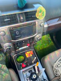 the interior of a car with an electronic device and various items on it's dash board