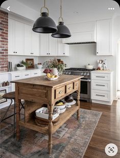 a kitchen island with two hanging lights above it and an area rug on the floor