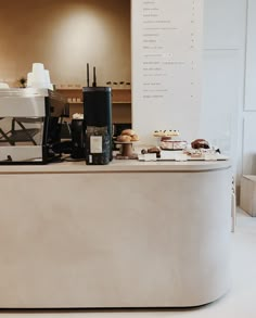 a counter with pastries and coffee machines on it's sides in a cafe