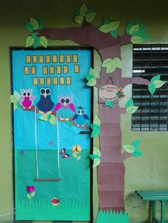 a door decorated with owls sitting on a tree branch in front of a green bench