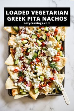 loaded vegetarian greek pita nachos on a tray