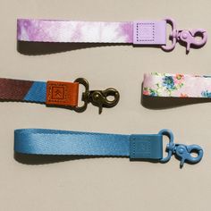 three different colored leashes with metal hooks