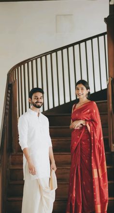 a man and woman standing in front of some stairs