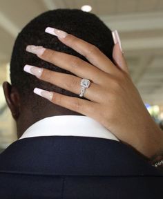 a man with his hands on his head and two rings on his face, wearing a suit