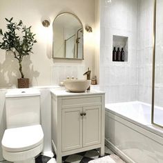 a white bathroom with black and white checkered flooring on the floor, sink, toilet and bathtub