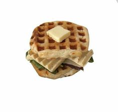 a waffle sandwich with cheese and lettuce is shown on a white background