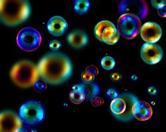 soap bubbles floating in the air on a black background with multicolored circles around them