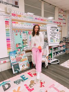 a woman in pink pants standing next to a display of crafting supplies on the floor