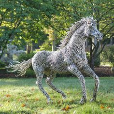 a sculpture of a horse is in the grass