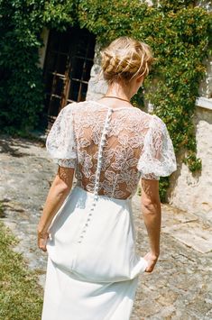 the back of a woman's dress with white lace on it and buttons at the waist