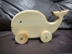 a wooden toy car sitting on top of a leather couch