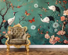 a chair sitting in front of a wall with flowers and birds on it