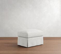 a white ottoman sitting on top of a wooden floor