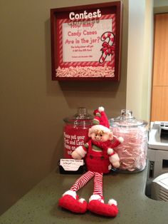 a candy bar with a teddy bear dressed as an elf and some candies on the counter